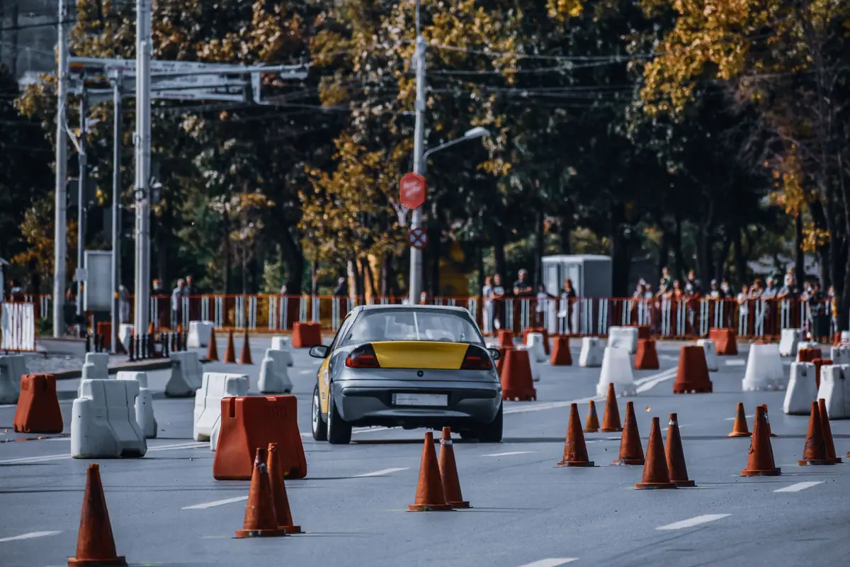 A car driving between traffic cones on a course