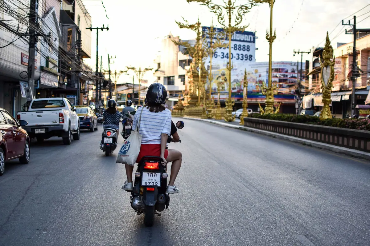 Motorcyclists riding along a city street in Thailand